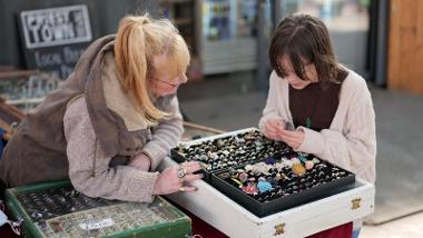 Trader helping child browse through items 