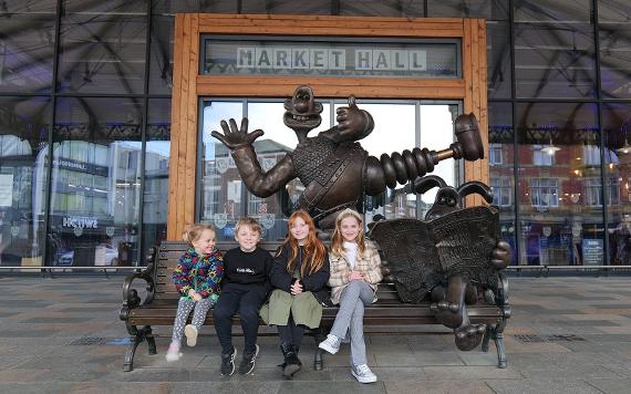 Children sat on Wallace and Gromit bench