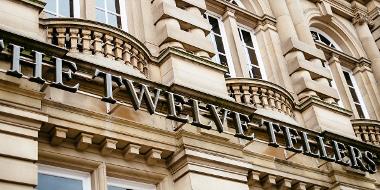 Close-up of The Twelve Tellers metal sign outside venue.